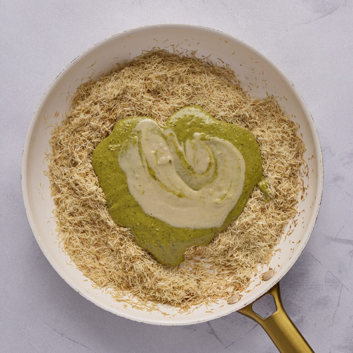 kataifi shredded dough after toasting in a skillet with pistachio cream and tahini added.