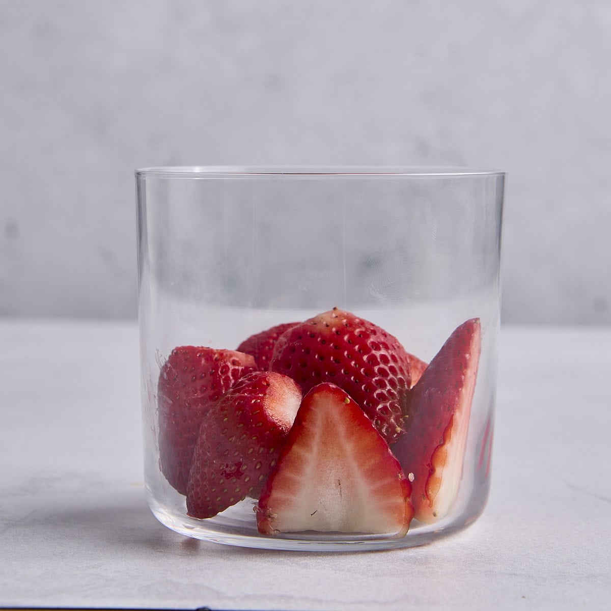 Fresh strawberries in a small glass dessert cup.