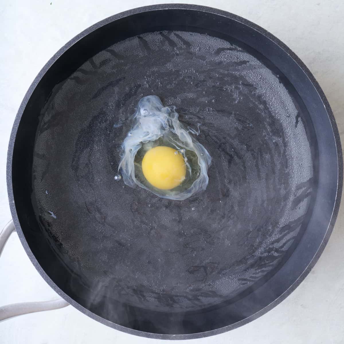 Egg in poaching water.