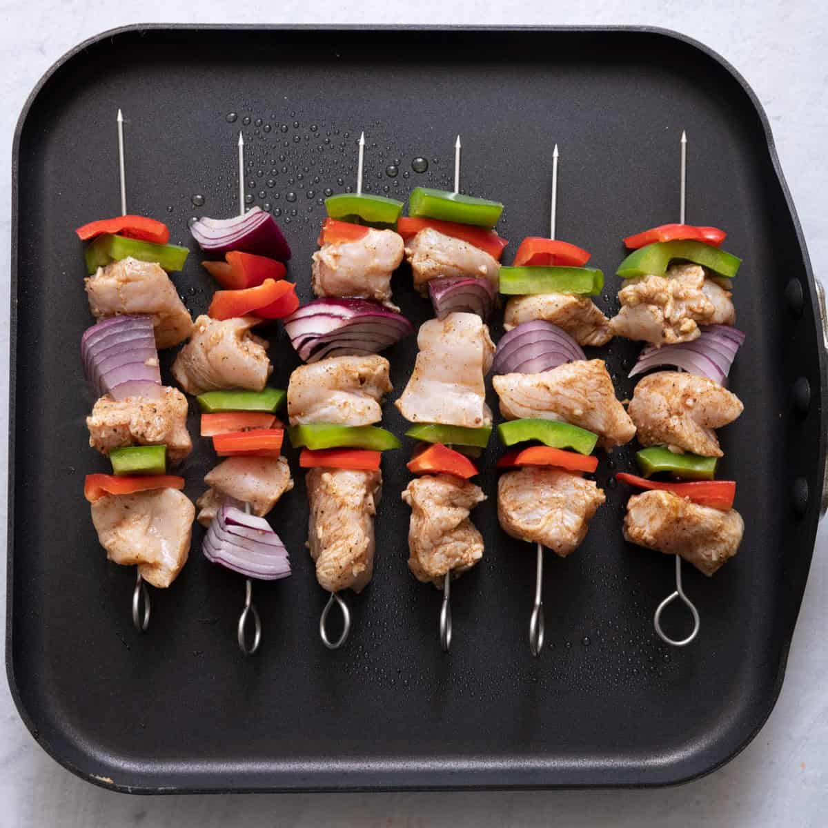 Skewer on grill pan before cooking.