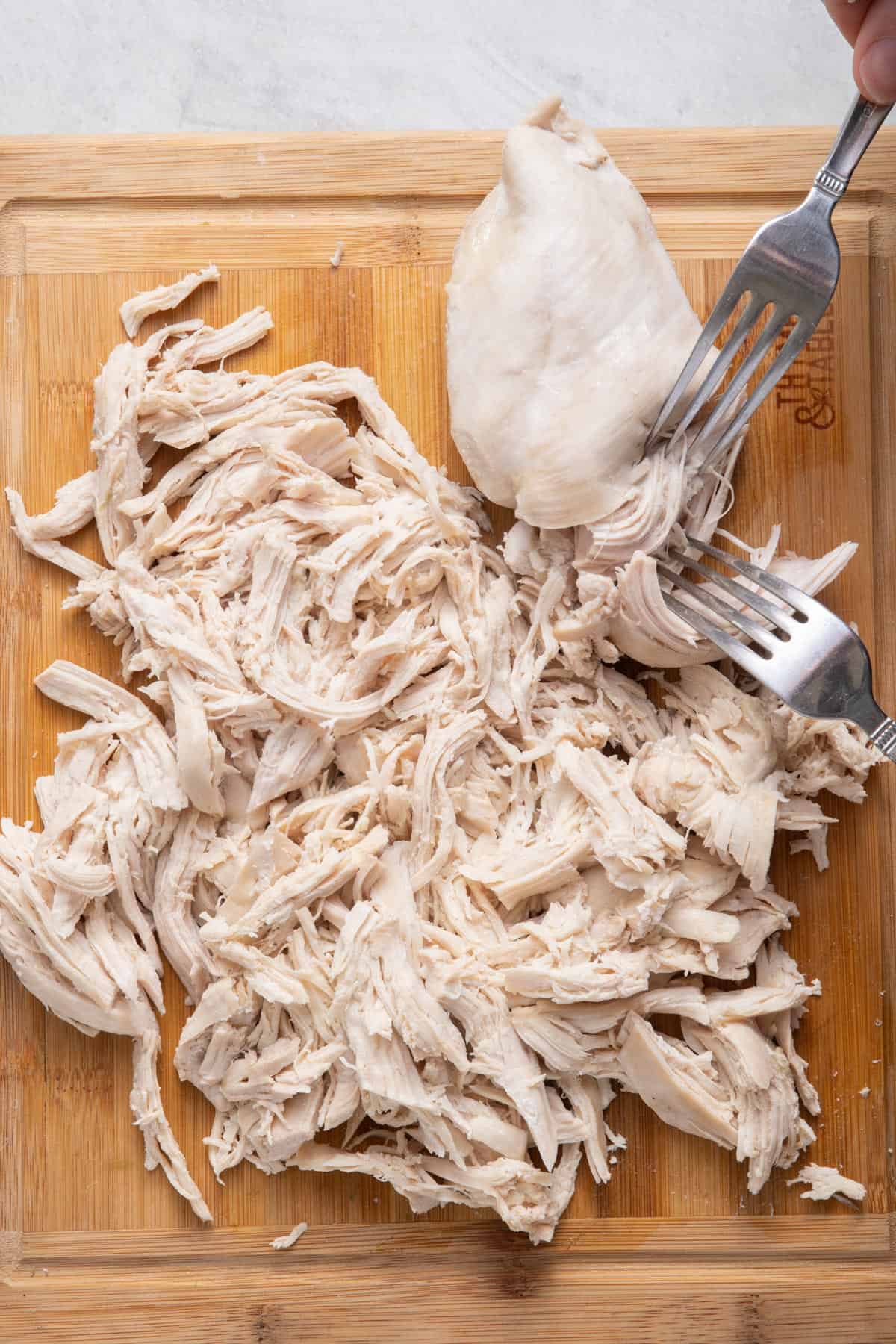 After chicken has been shredded with one more piece being shredded with two forks.