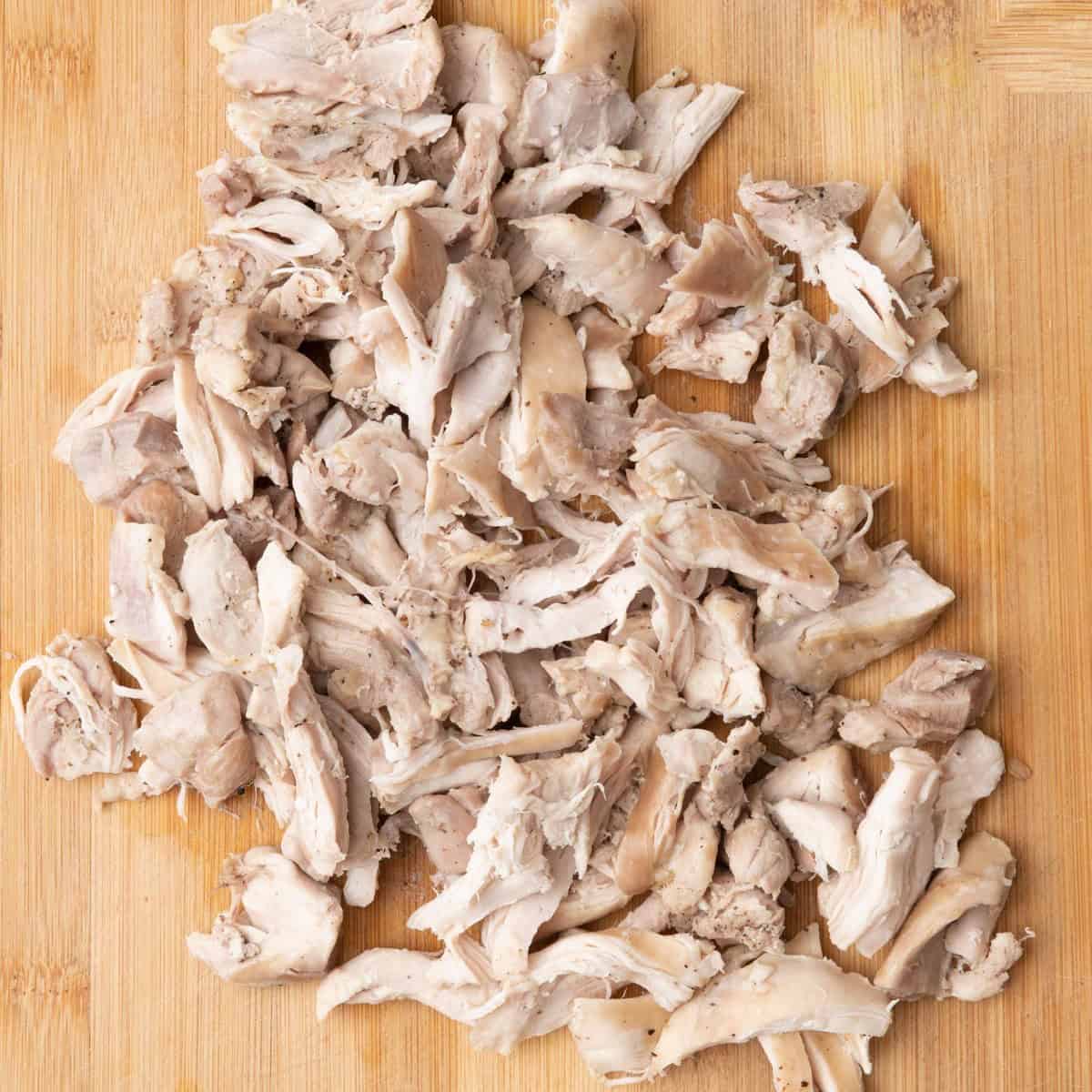 Chicken shredded on cutting board.