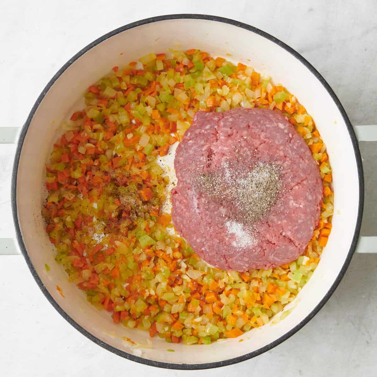 Ground beef, salt and pepper added to cooked veggies.