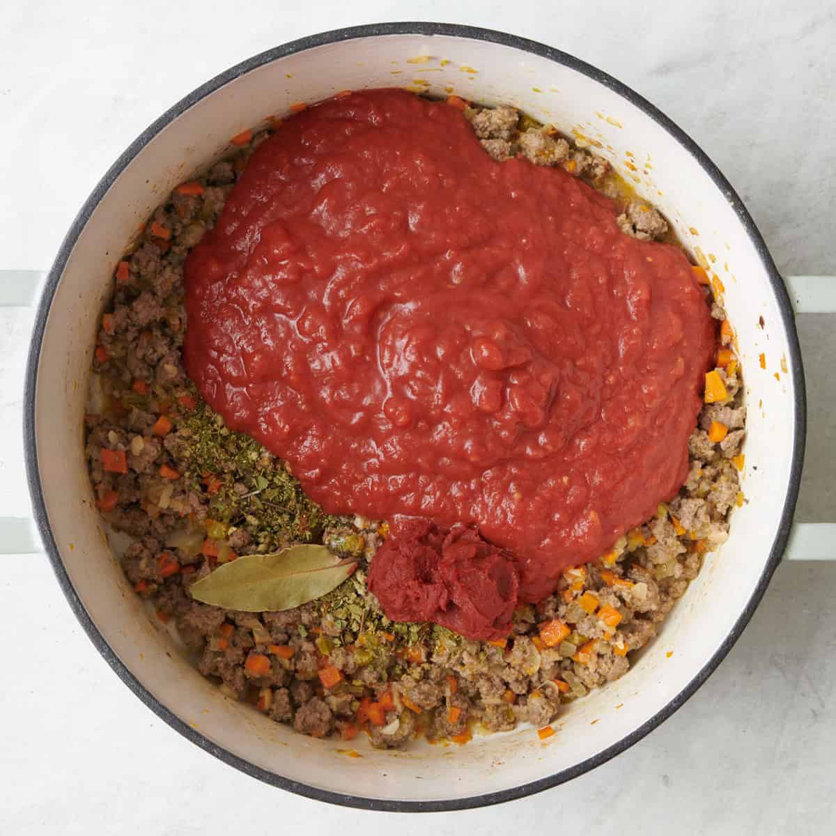 Tomatoes, bay leaf and spices added.