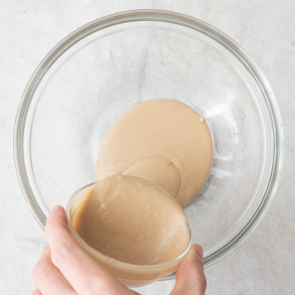 Pouring tahini into a bowl.