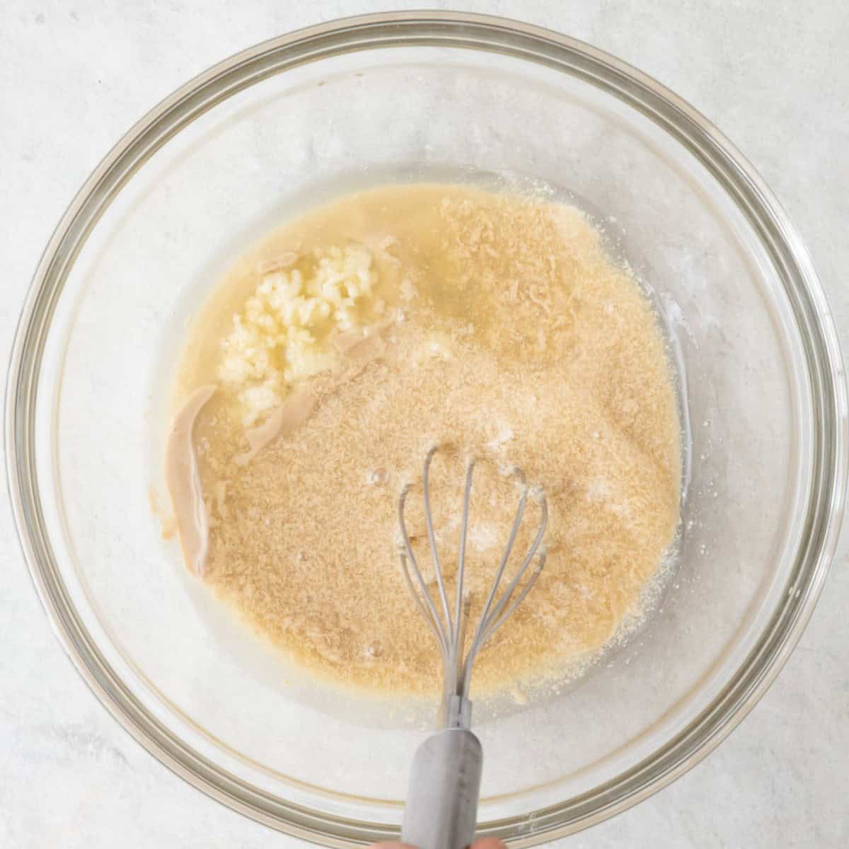 Whisking sauce ingredients in a bowl.