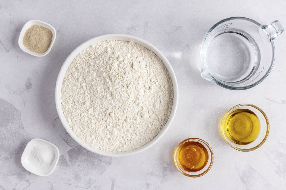 Ingredients for recipe: flour, instant yeast, salt, honey, oil, and water.