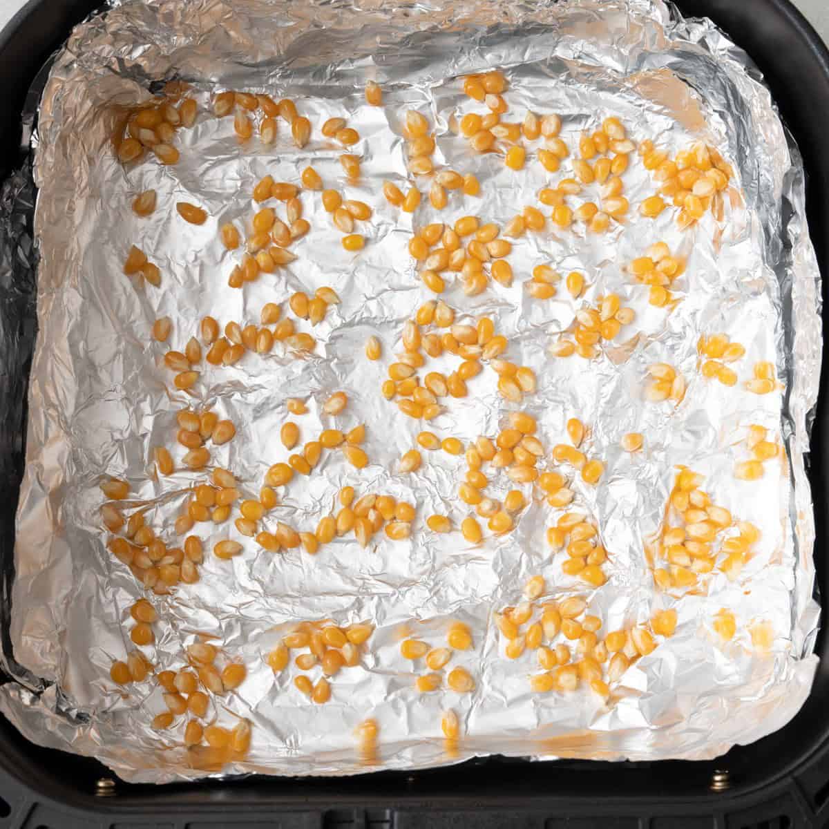 Popcorn in basket before popped showing them spread out in a single layer.