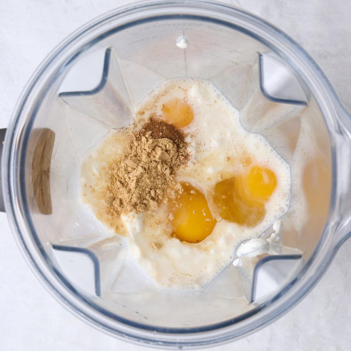 Eggs, milk, yogurt, maple syrup, vanilla and spices in a blender.