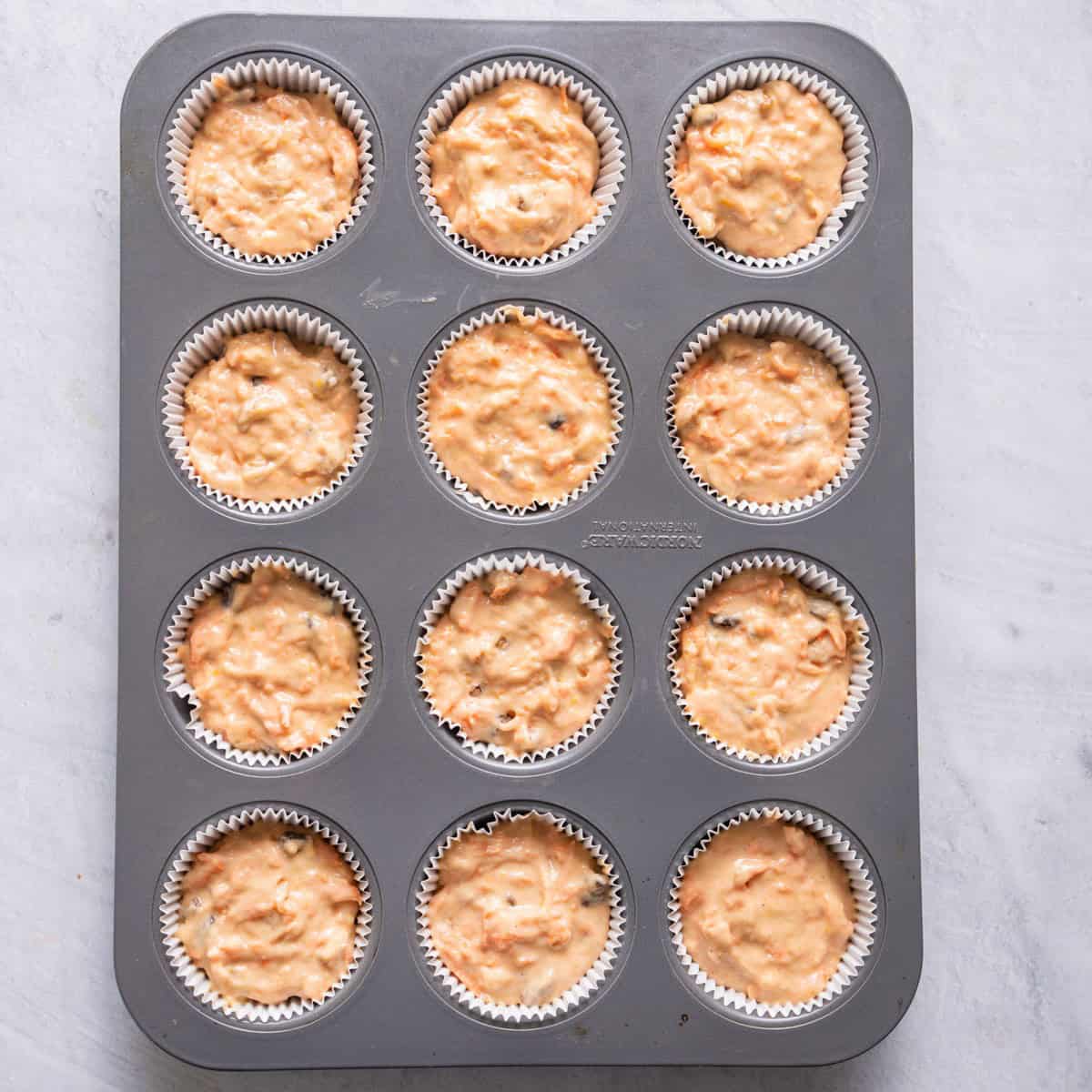 Batter divided into lined muffin pan before baking.