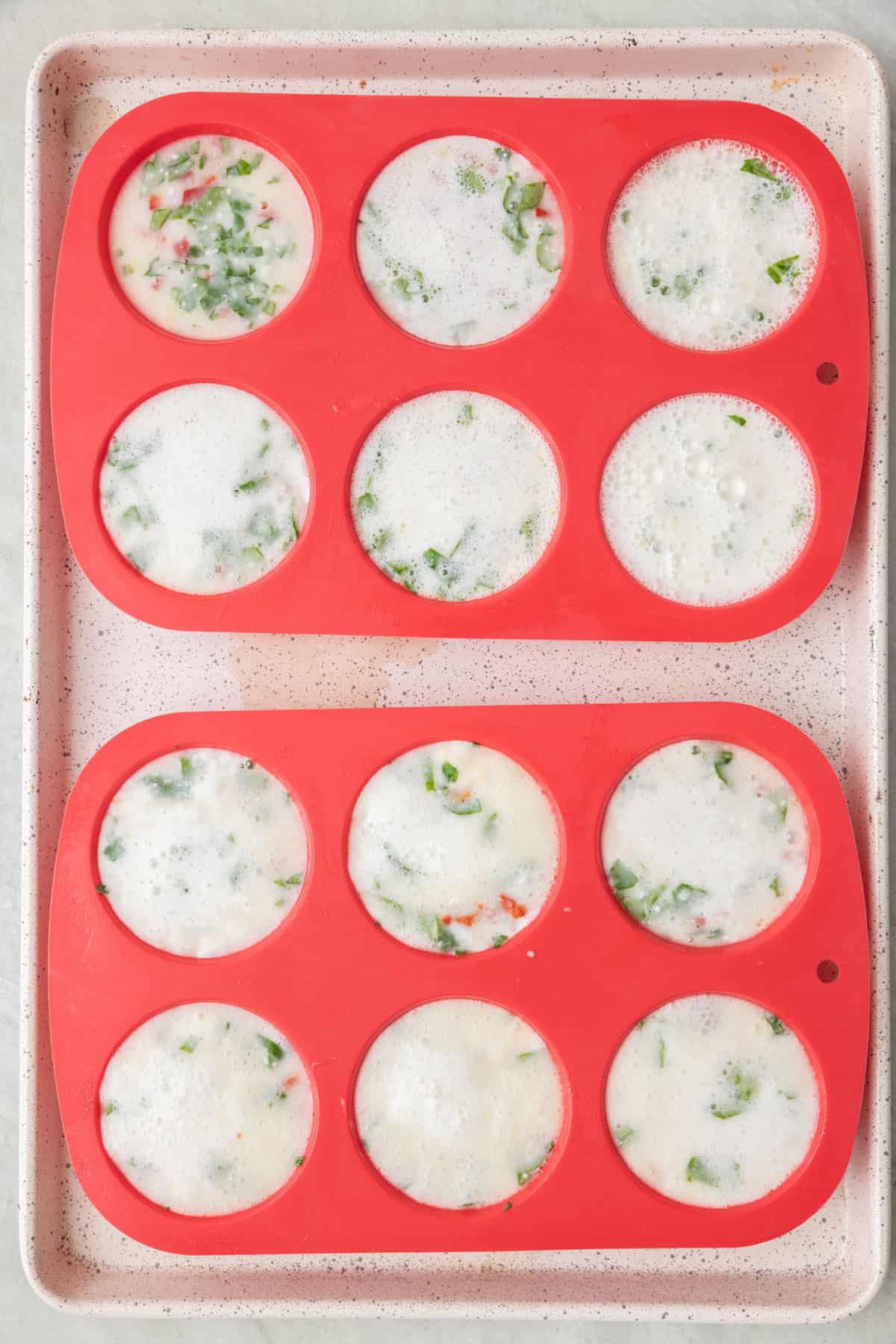 Baking dish with silicone tray filled almost all the way up with egg white mixture