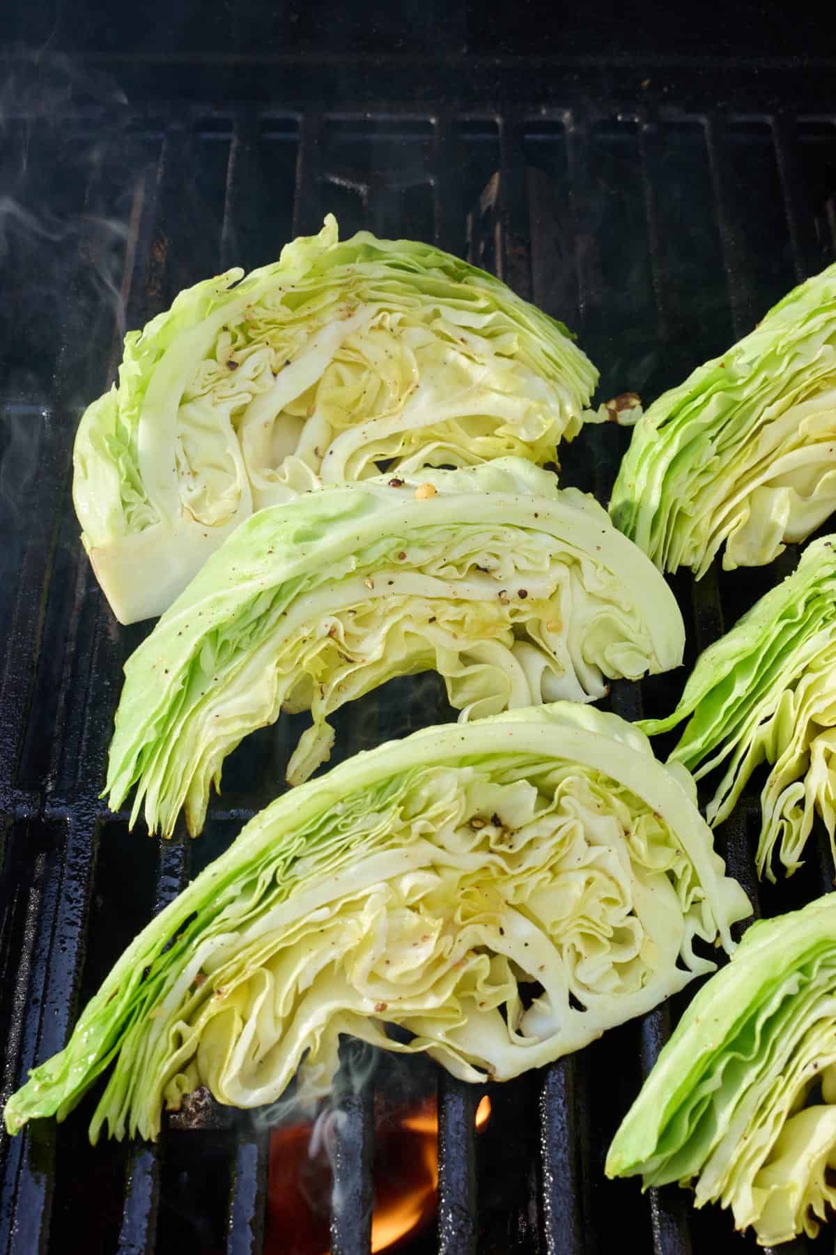Seasoned cabbage wedges on an outdoor grill.
