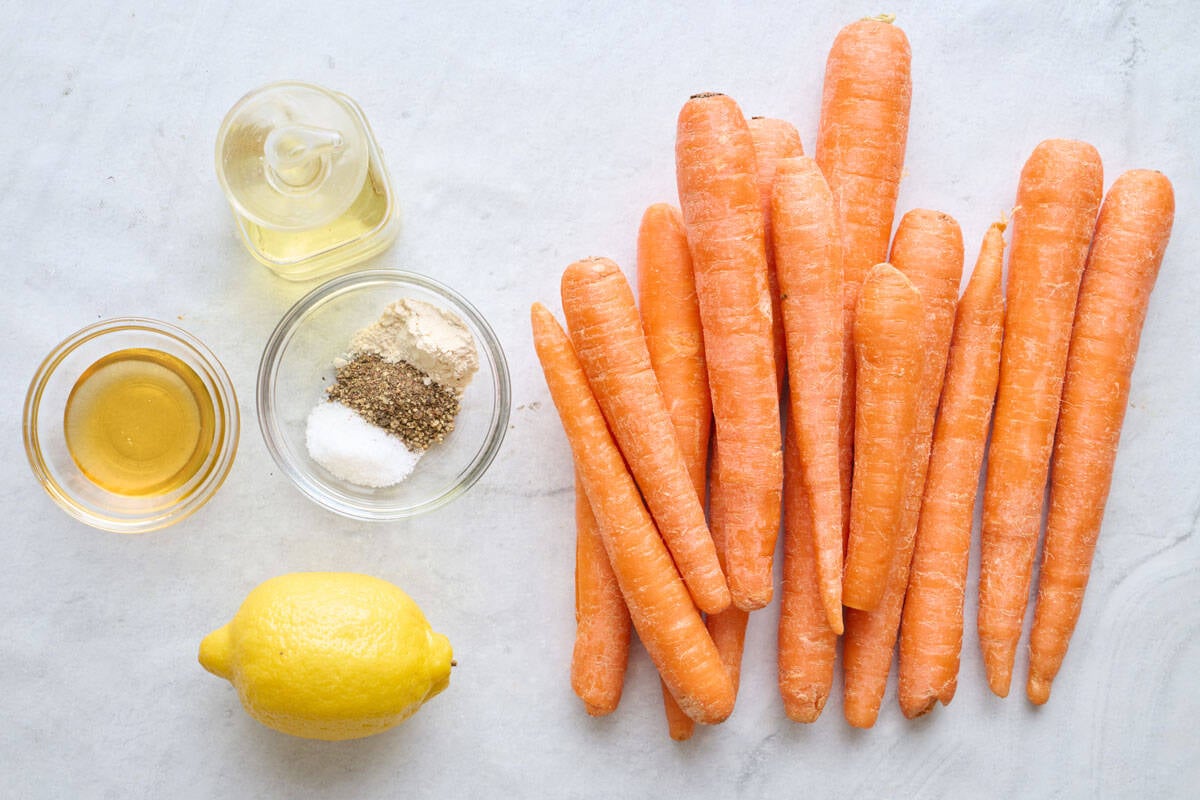 Ingredients for recipe: honey, oil, seasonings, lemon, and whole carrots.