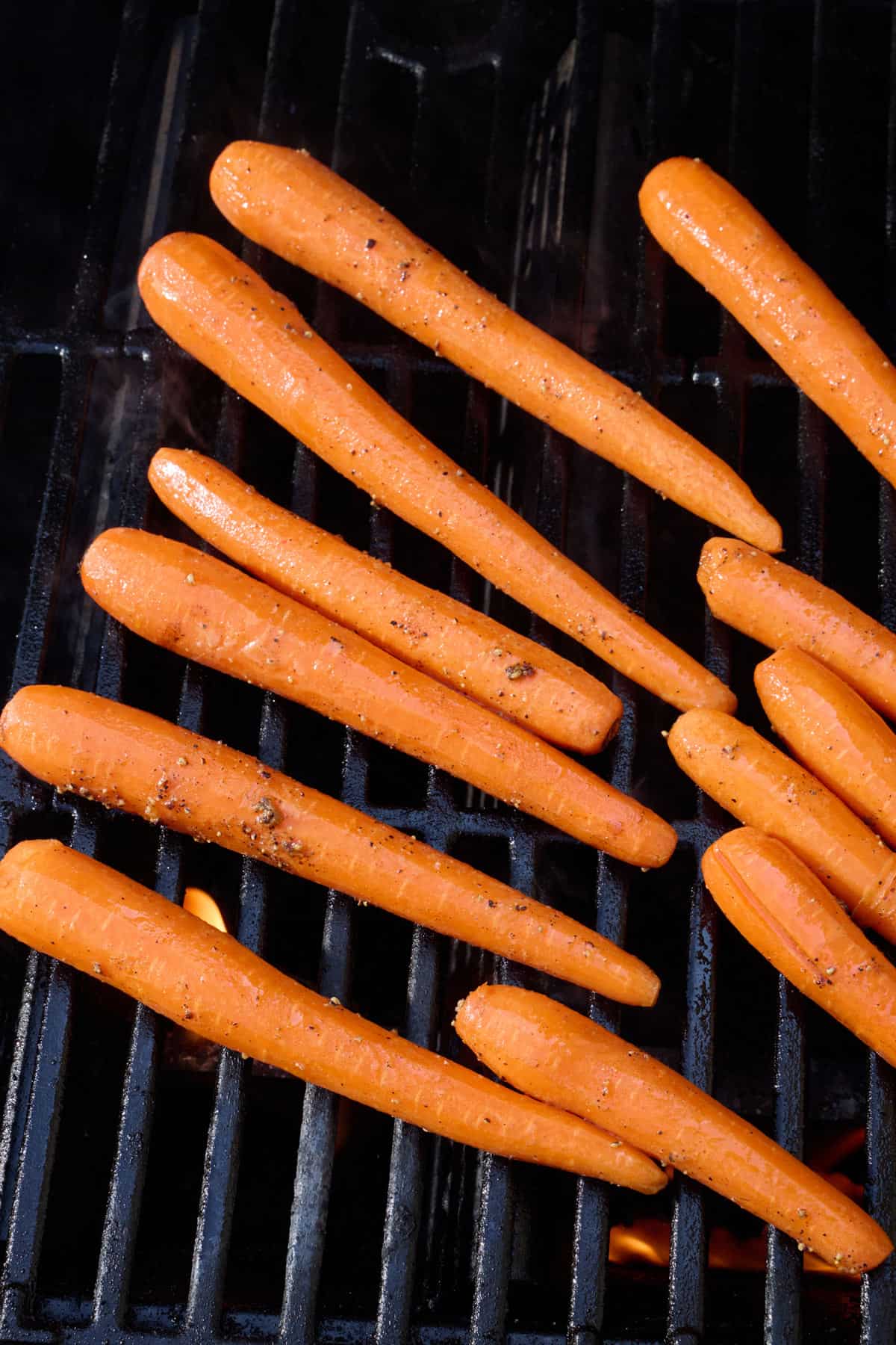 Seasoned carrots on an outdoor grill.