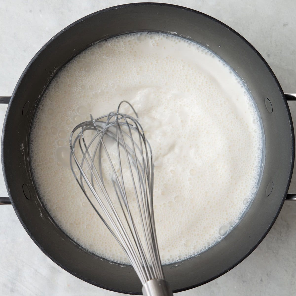 Whisking milk mixture before thickened.