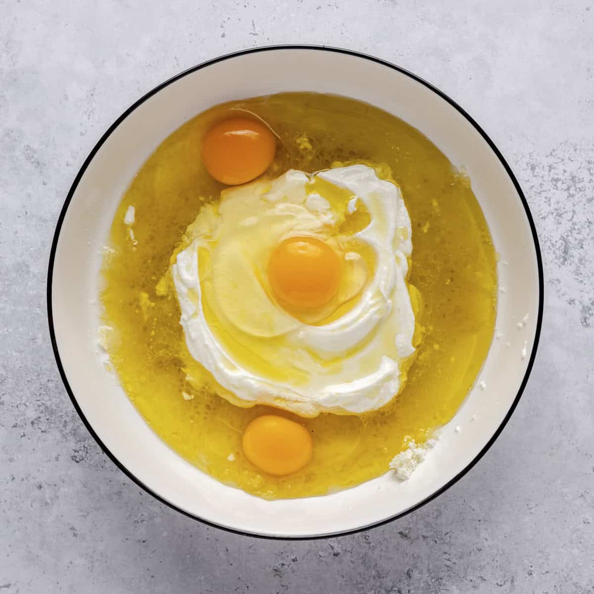 Eggs, yogurt, olive oil, and lemon juice added to sugar.