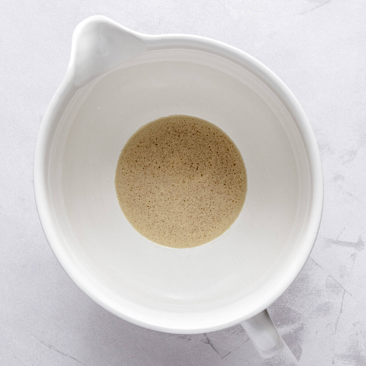 Water, honey, salt and yeast in the bowl of a stand mixer.