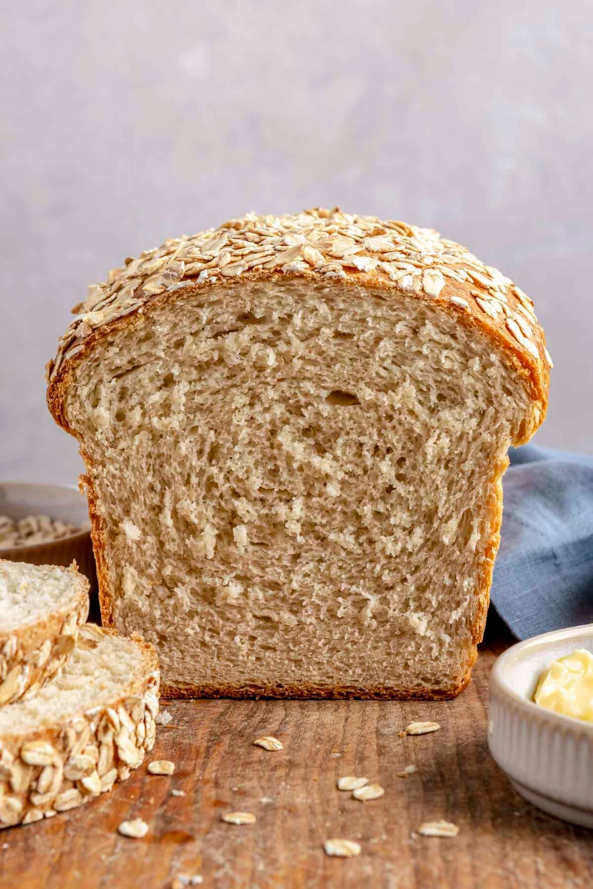 Oatmeal bread loaf with a slices removed to show inside texture.