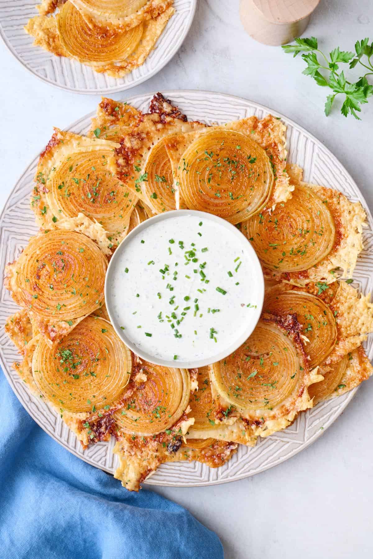 Onion ring chips on a platter with a small dish of ranch in the center.