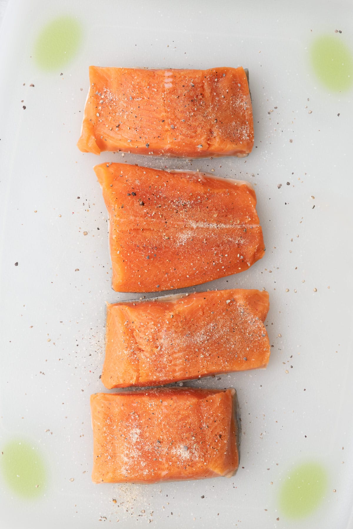 Salmon fillets on a cutting board and seasoned.