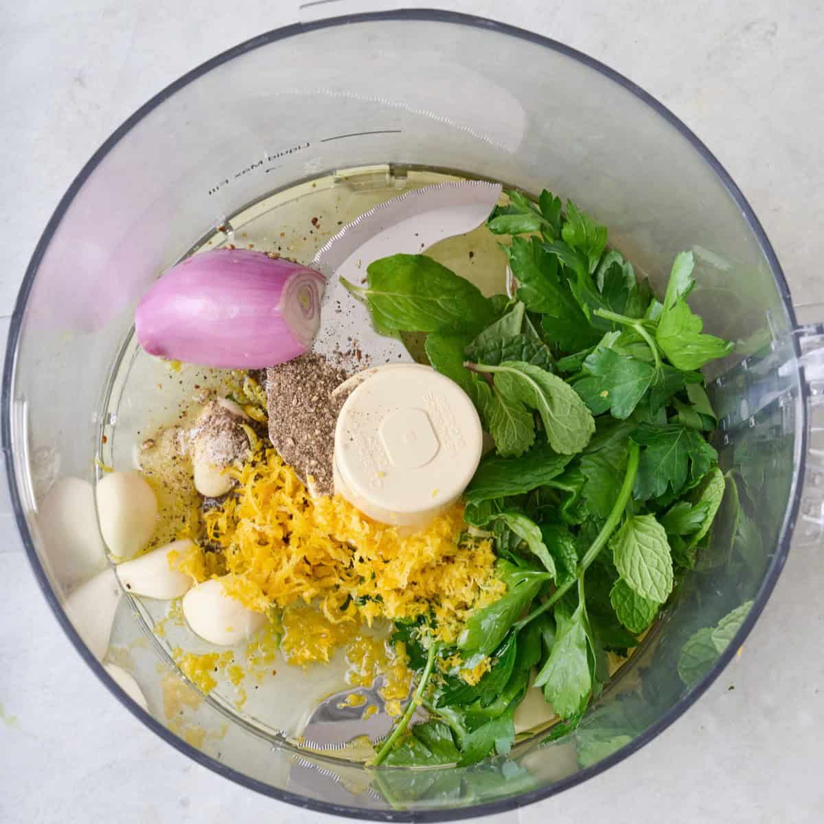 Herbs, garlic, lemon, oil and seasonings in a food processor.