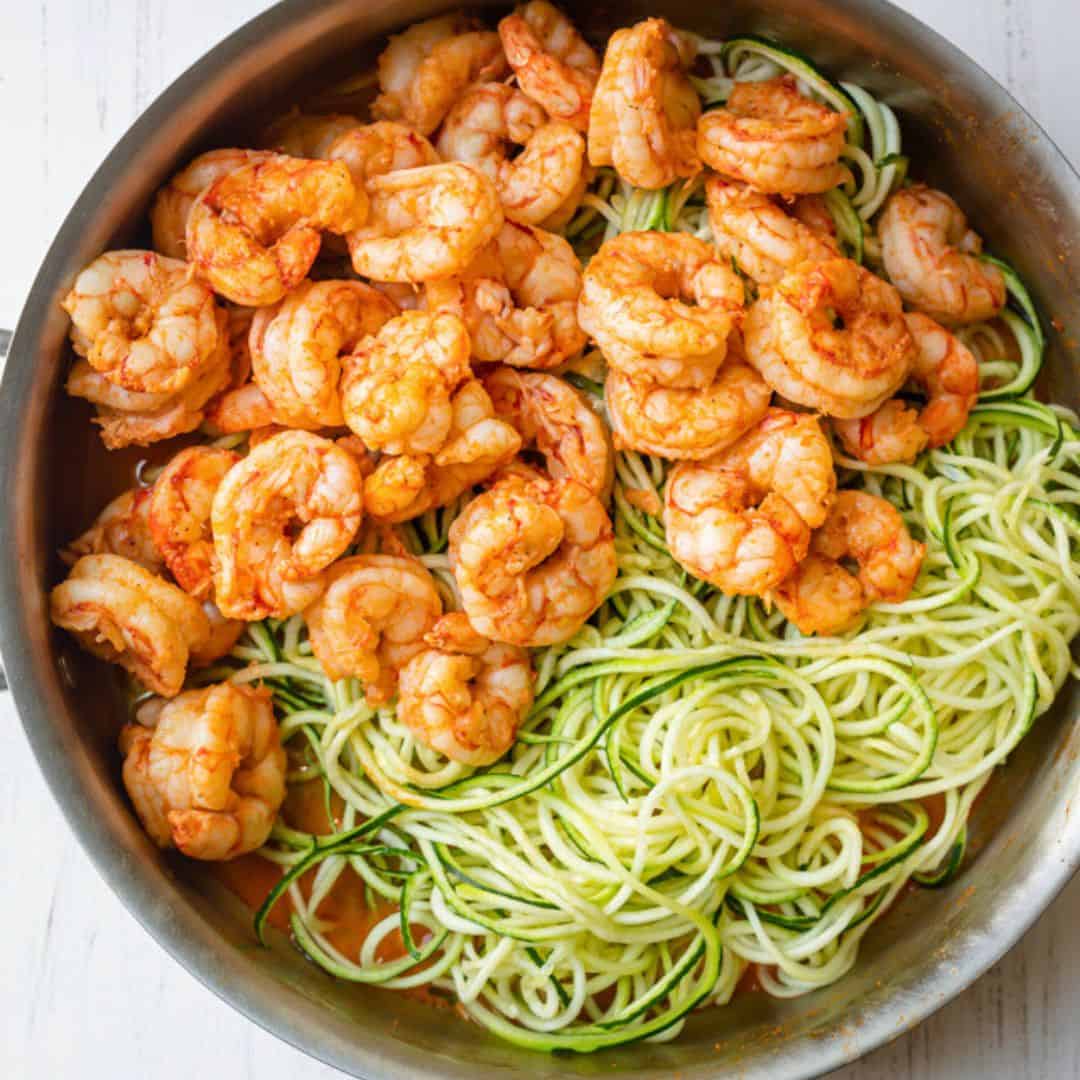 Cooked shrimp added to pan with sauce and zoodles.