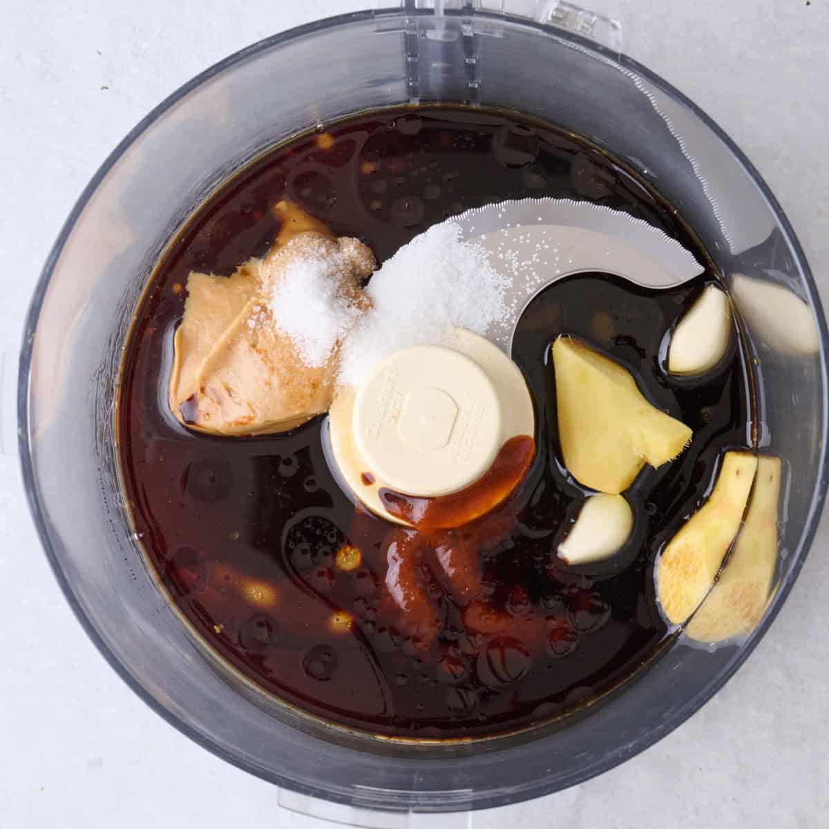 Dressing ingredients in the bowl of a food processor.