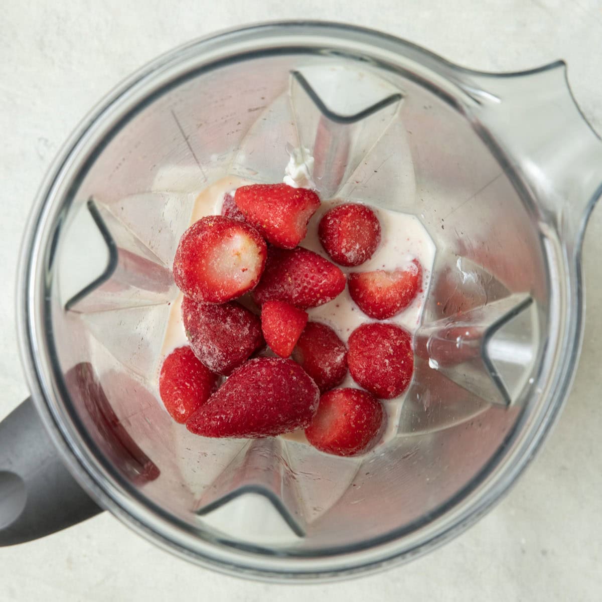 Strawberry popsicle ingredients in a blender before blending.