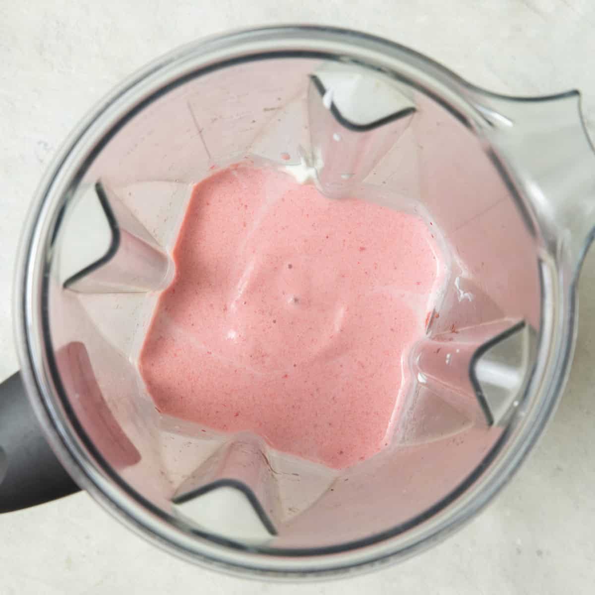Strawberry popsicle ingredients in a blender after blending.