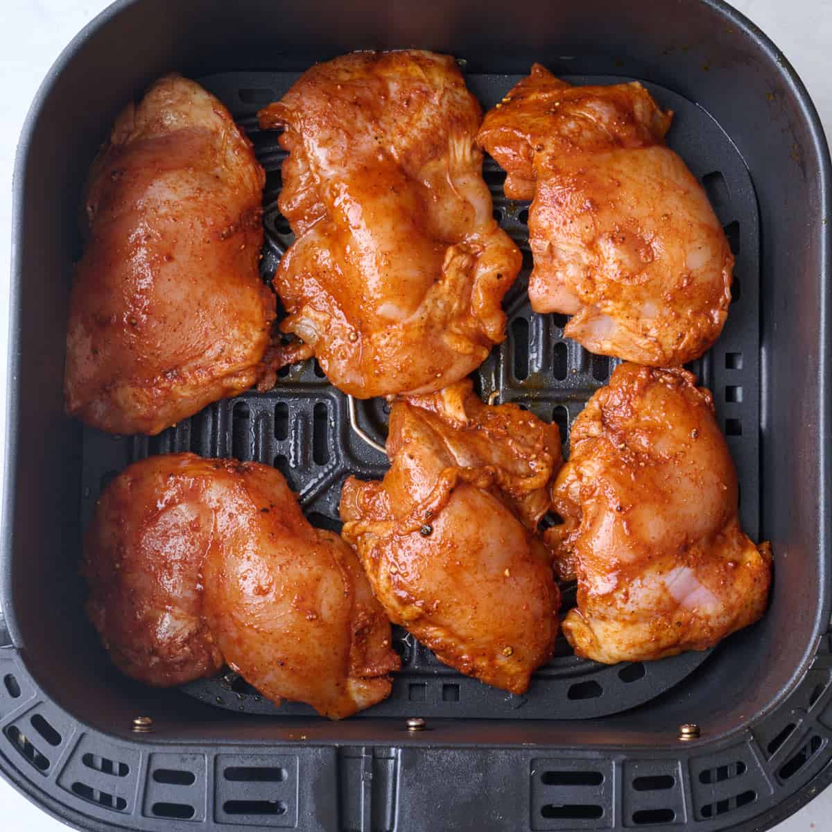 Recipe in an air fryer basket before cooking.