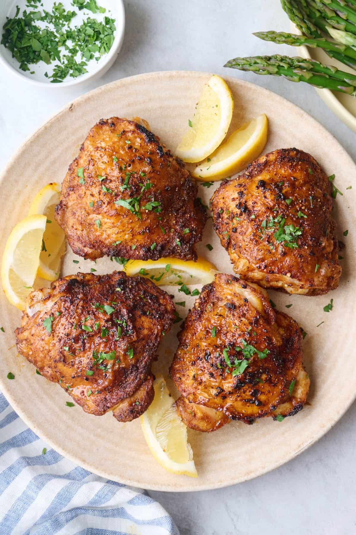 Air fryer bone in chicken thighs on a plate with crispy skin.