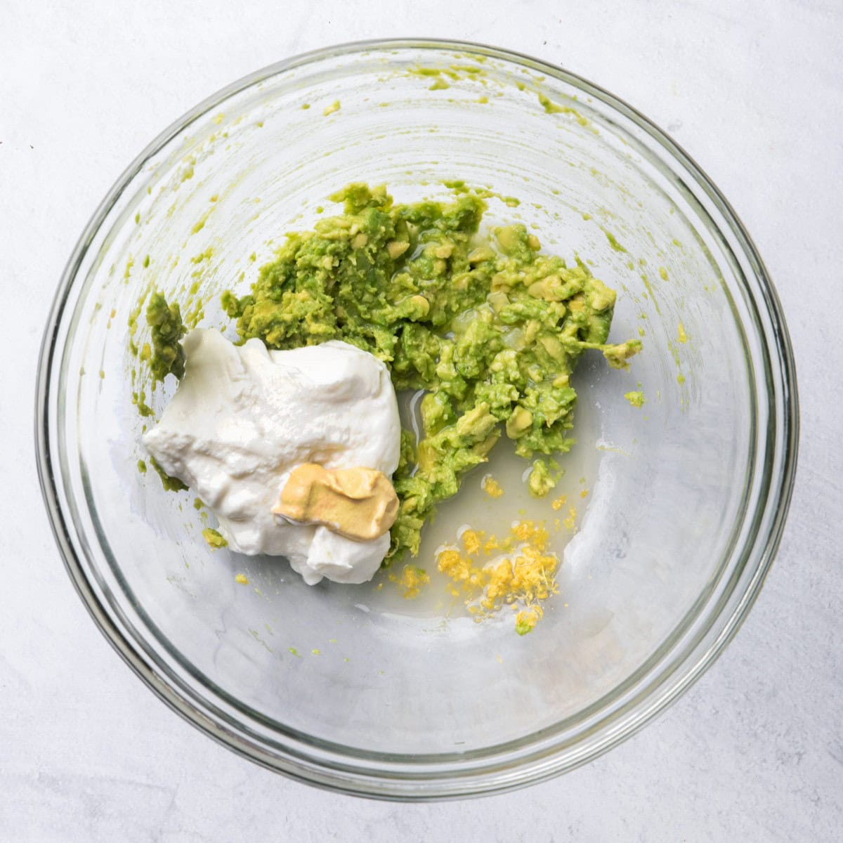 Yogurt, dijon mustard, lemon juice and zest, added to mashed avocado.