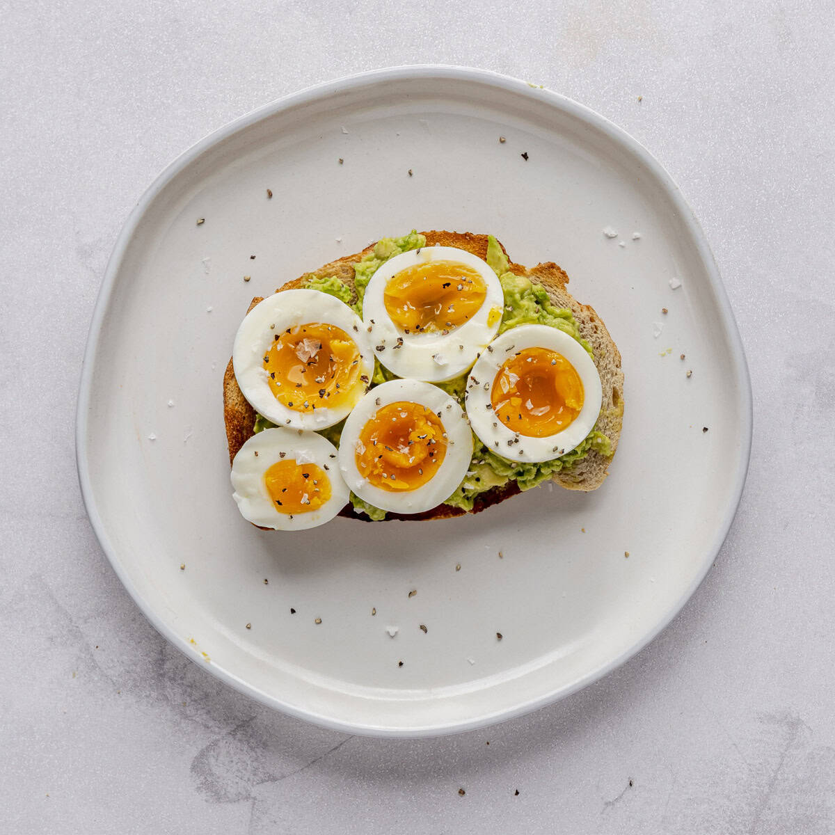 Avocado toast with sliced boiled egg, salt and pepper.