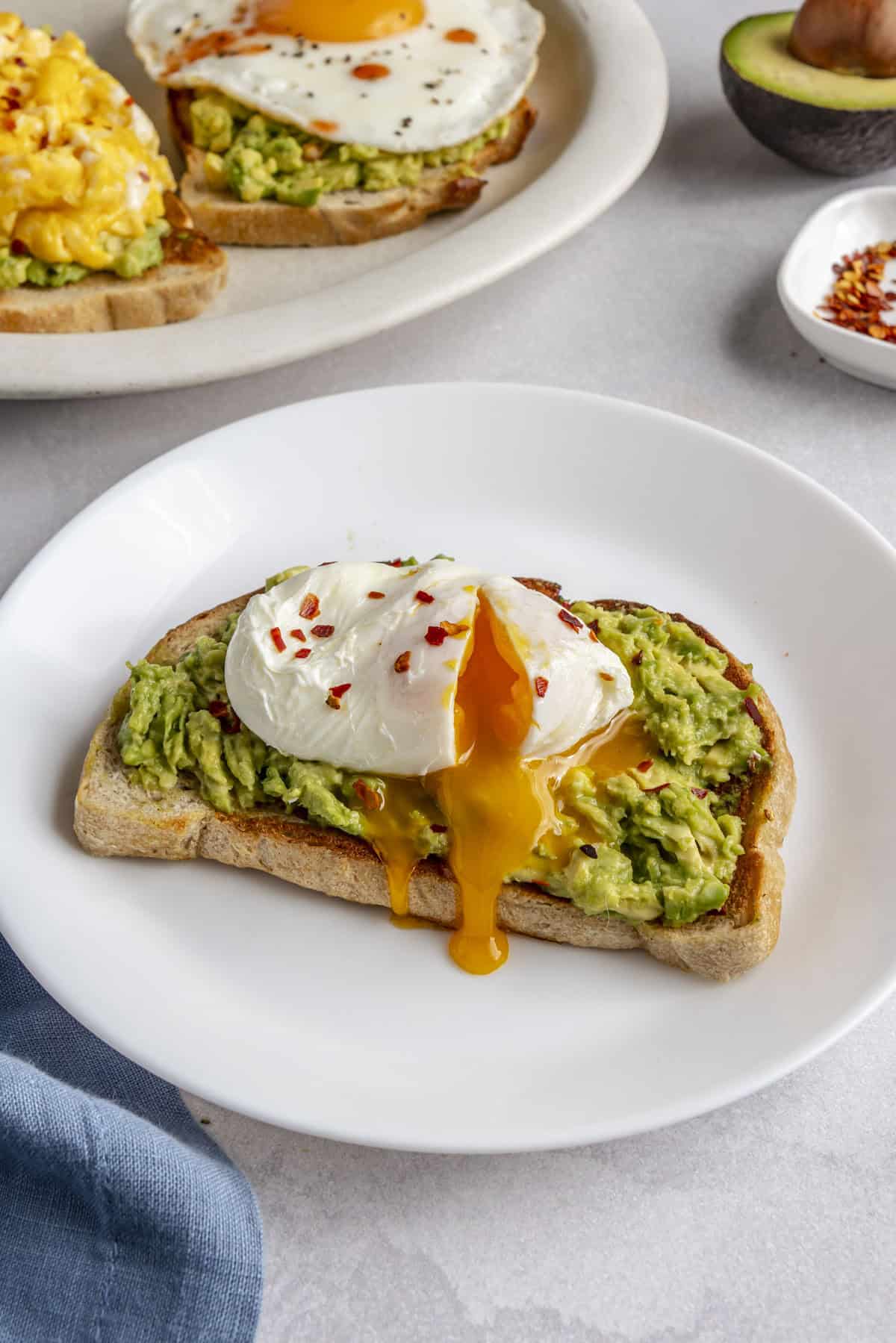 Runny poached egg on mashed avocado sourdough toast.