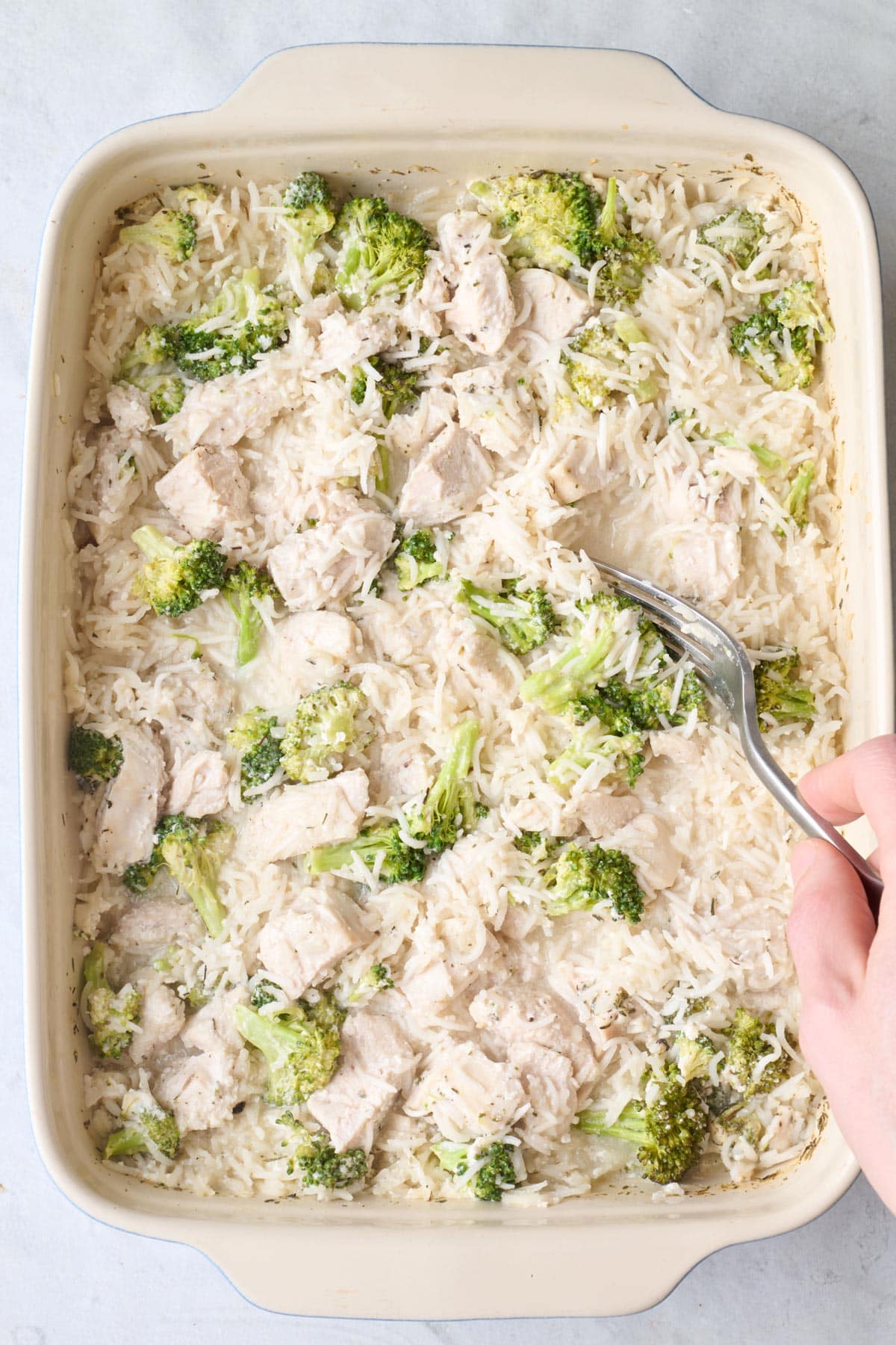 Casserole after most liquid is absorbed with a fork fluffy rice.