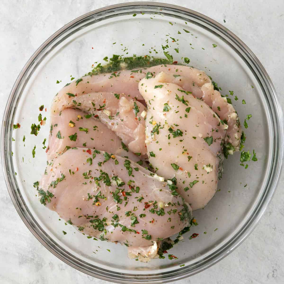 Chicken breast after tossing in cilantro marinade.