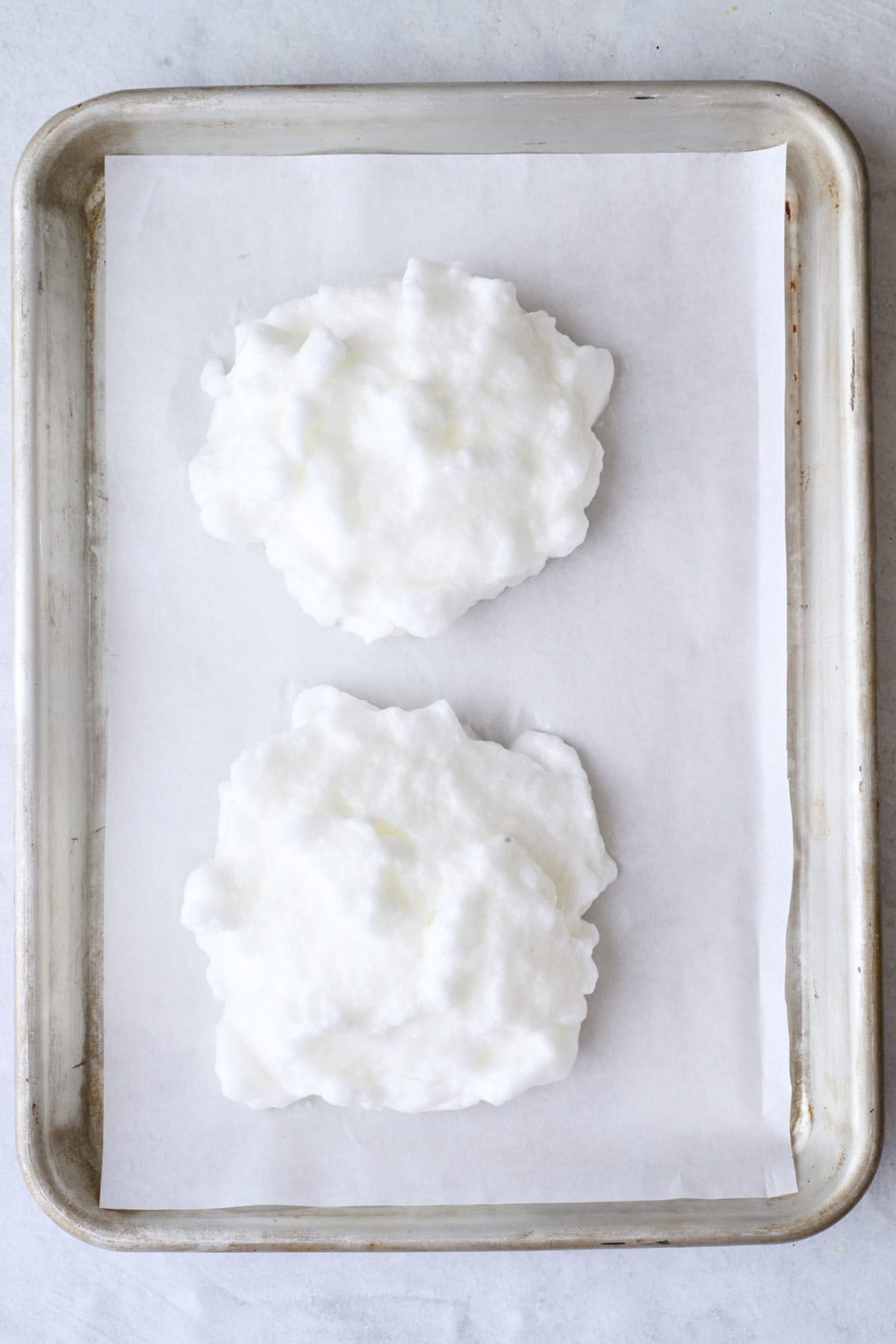 Two pieces of white rice on a baking sheet