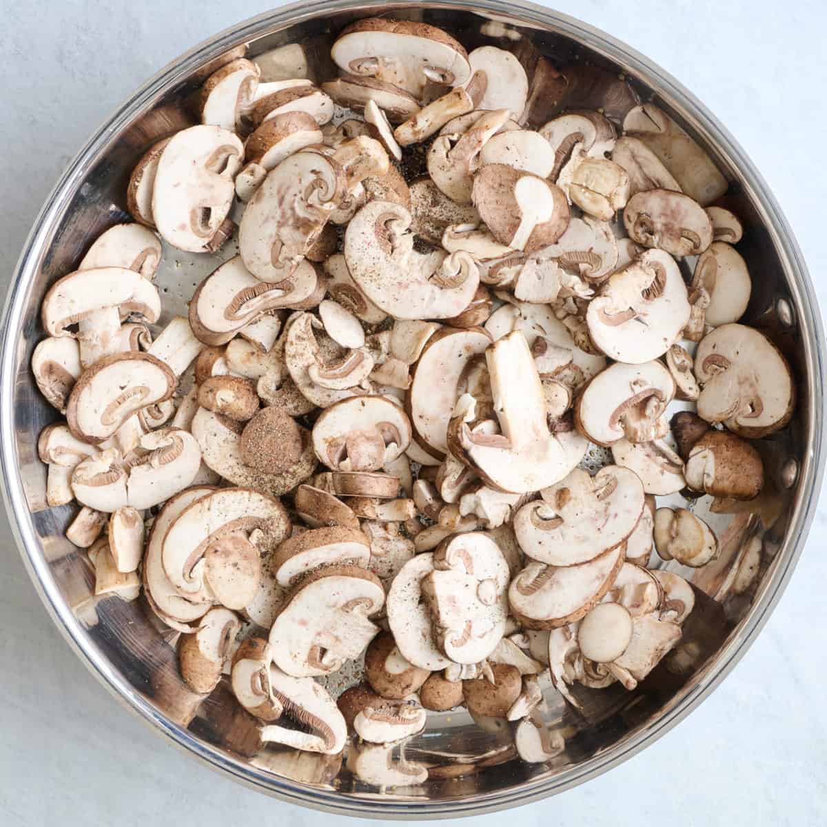 Oil, mushrooms and black pepper in a skillet.