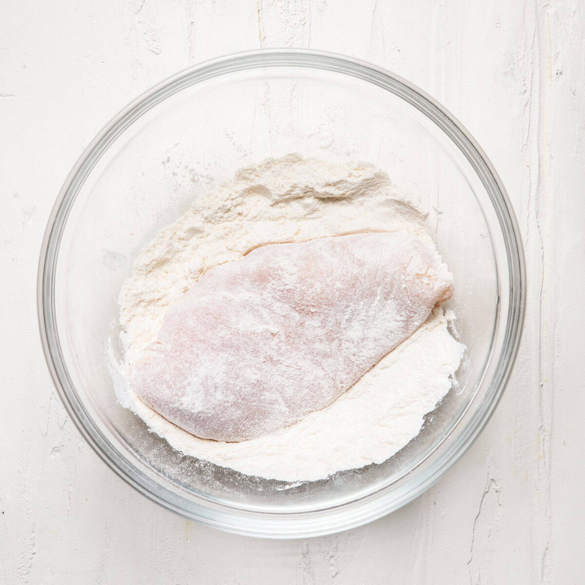 Chicken breast dredged in flour.