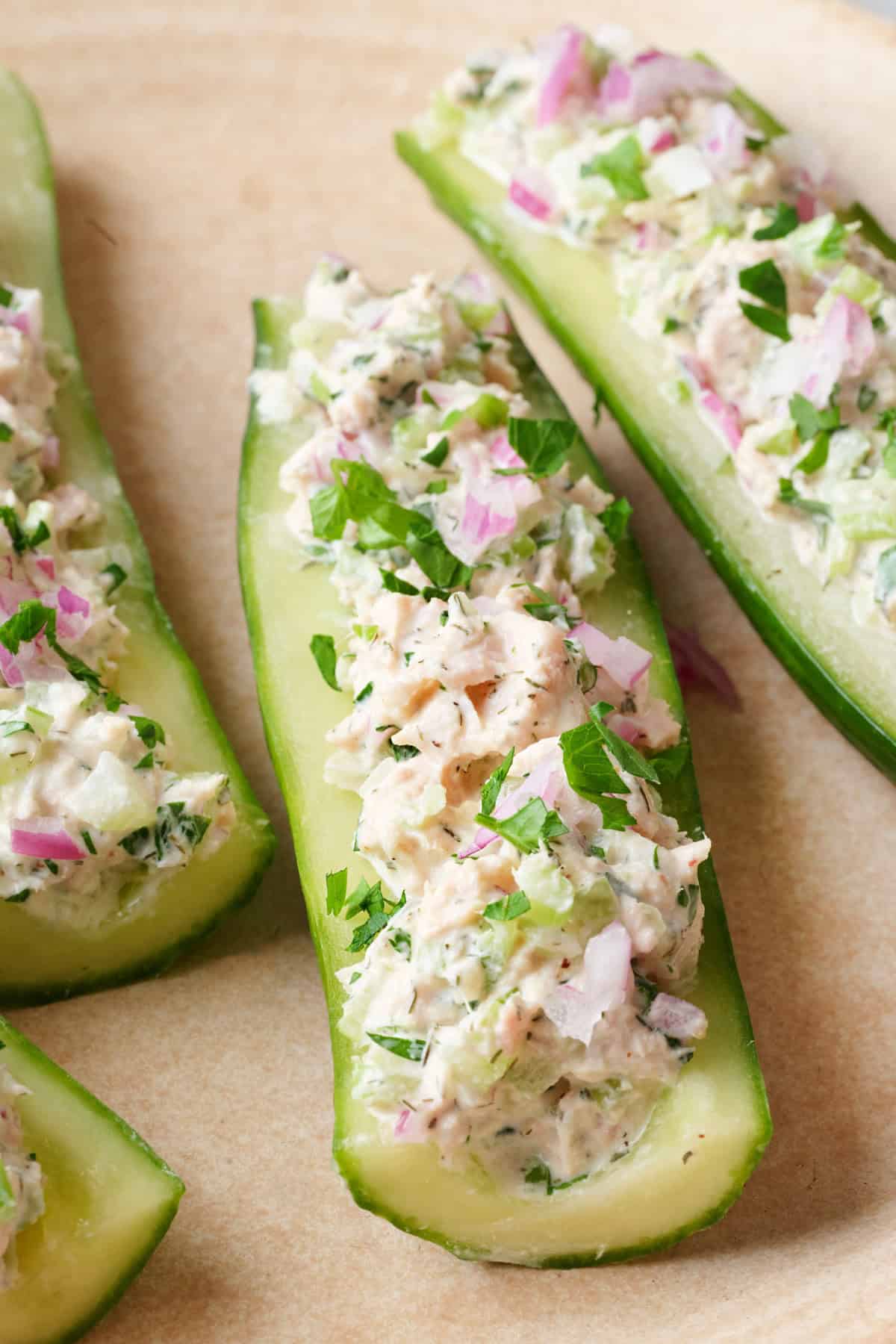 Tuna salad in a cucumber boat topped with fresh parsley.