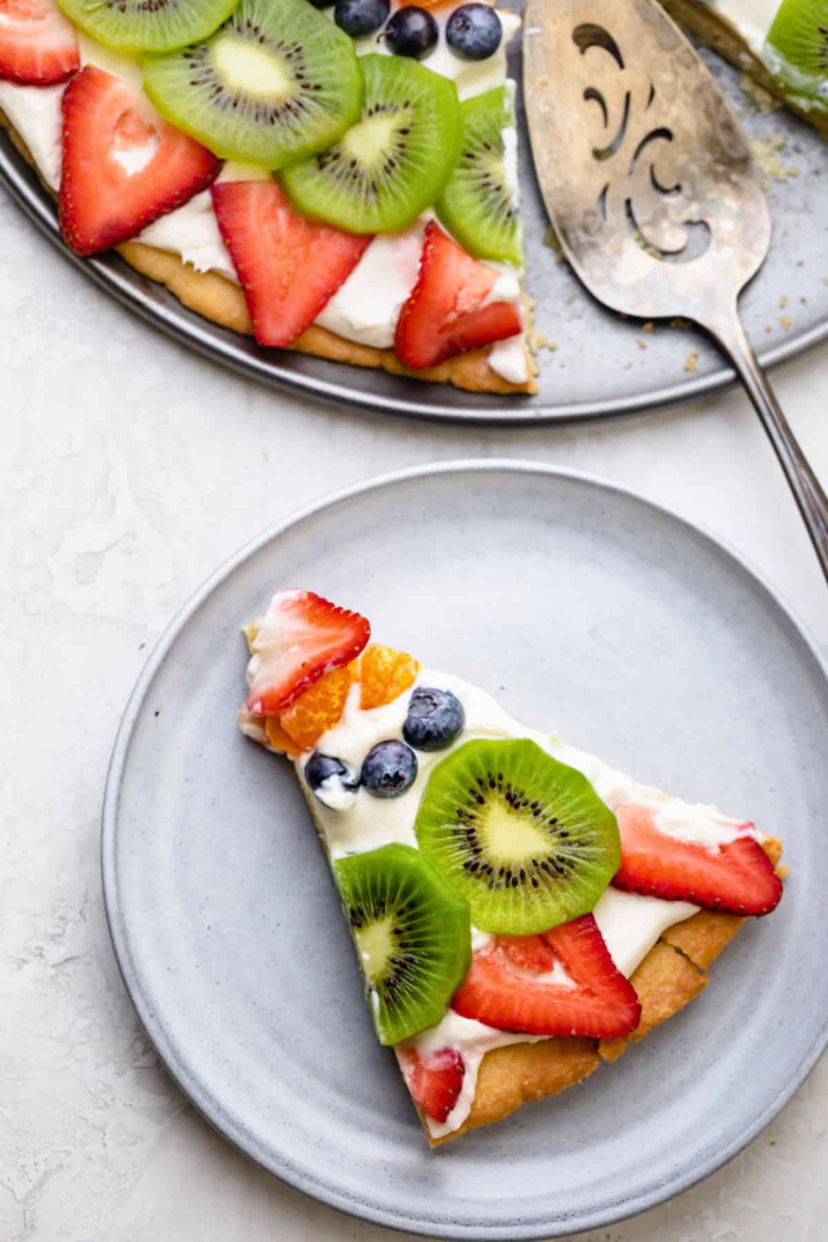 Slice of fruit pizza on a plate.
