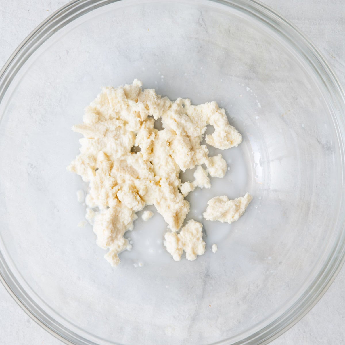 Torn white bread and milk in large bowl.