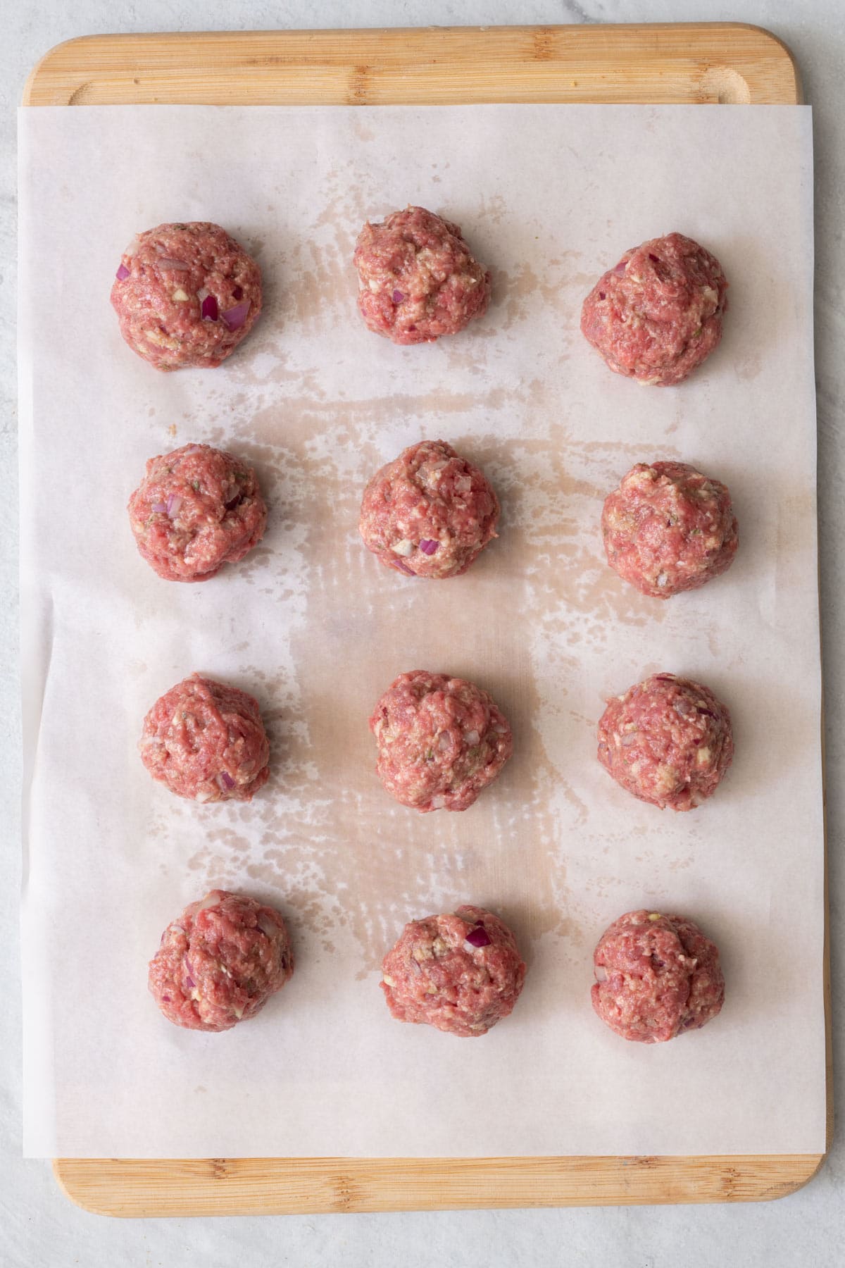 Meatballs on cutting board on wax paper.