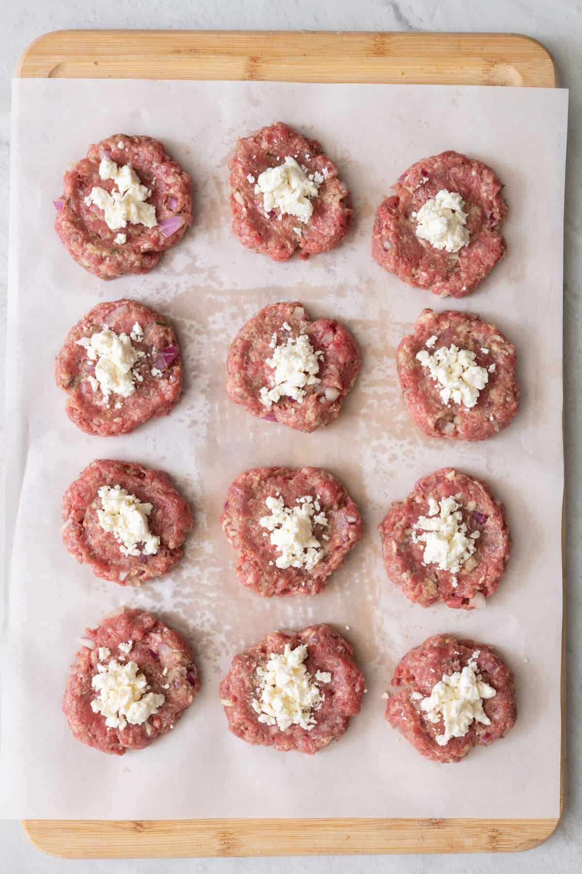 Meatballs flattened with feta cheese inside.