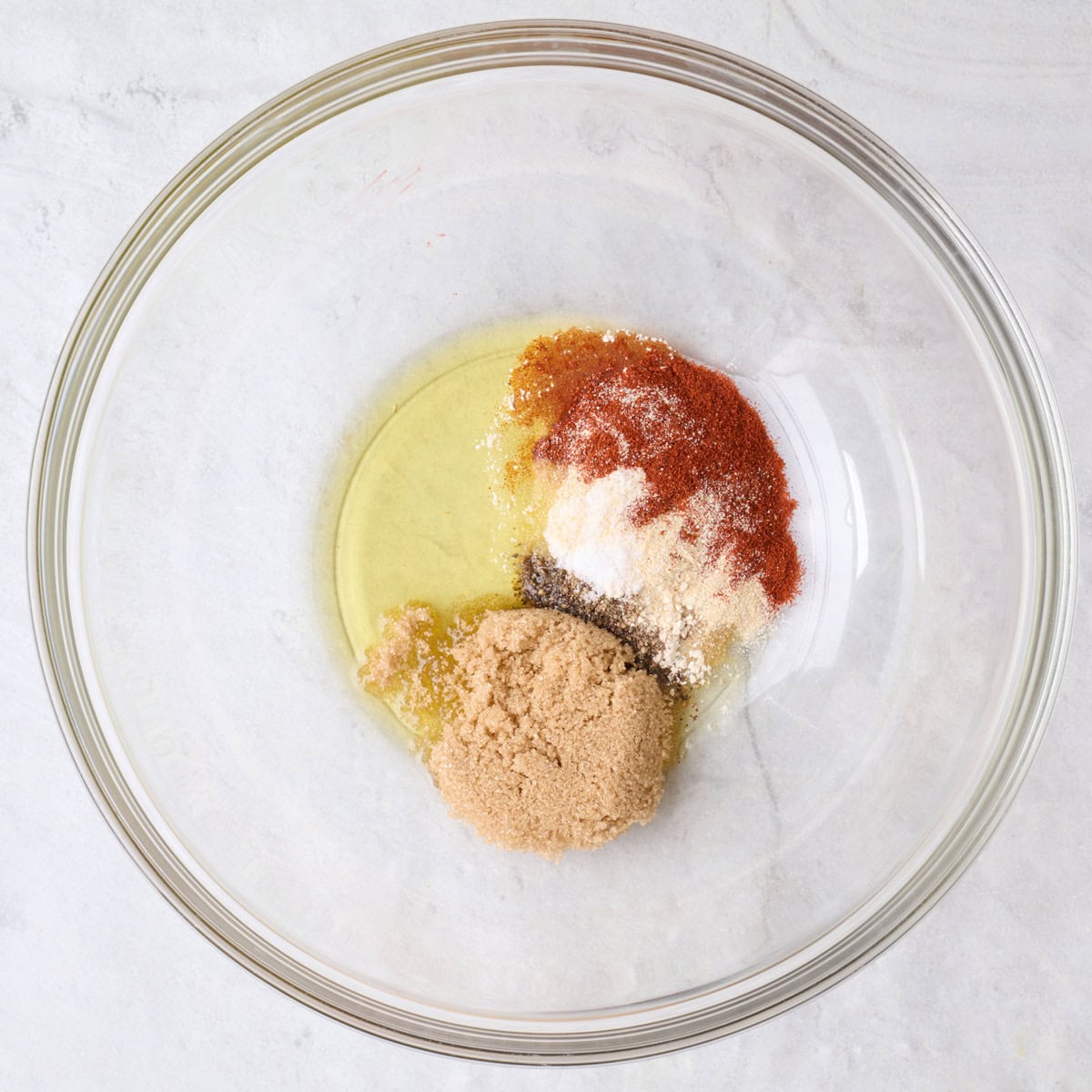 Seasonings and oil in a bowl before mixing.