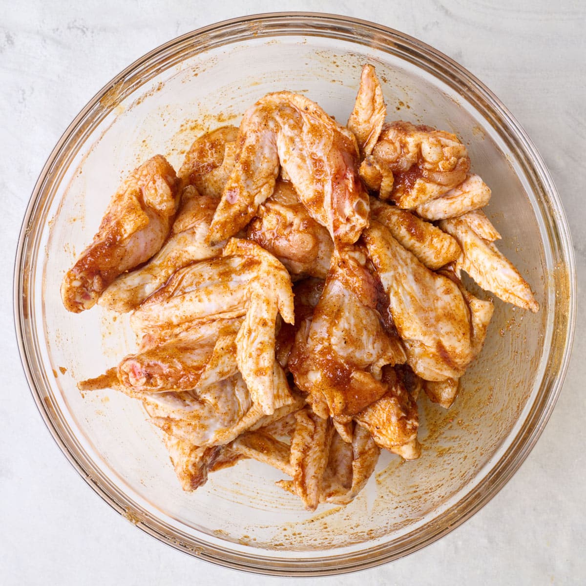 After tossing chicken wings with marinade.