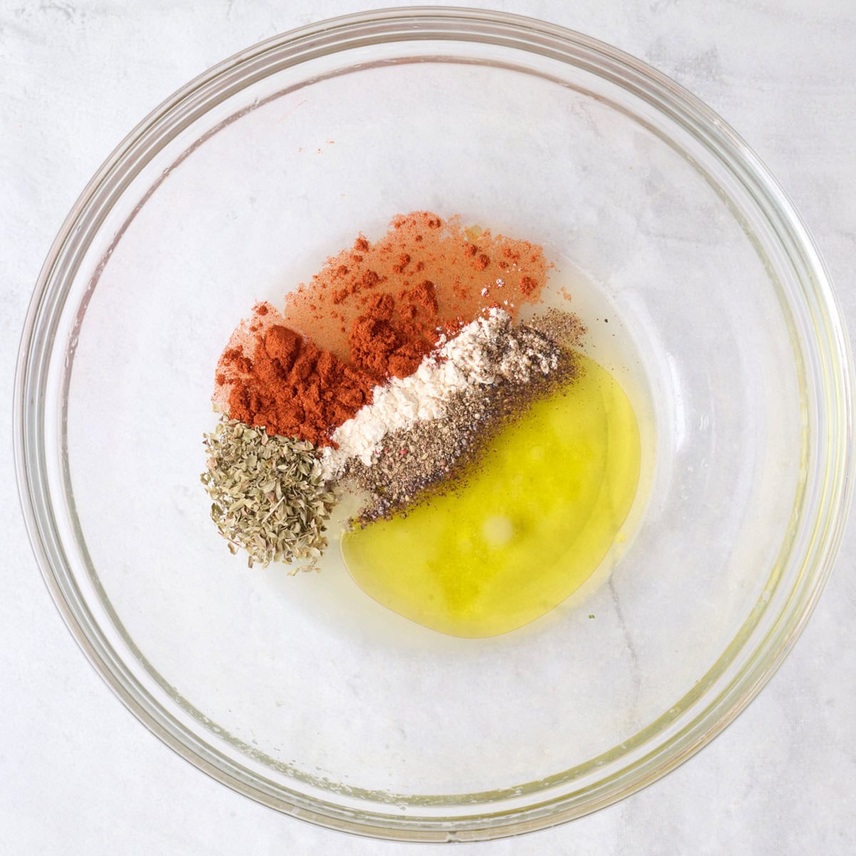 Oil, lemon juice, and seasonings in a large bowl.