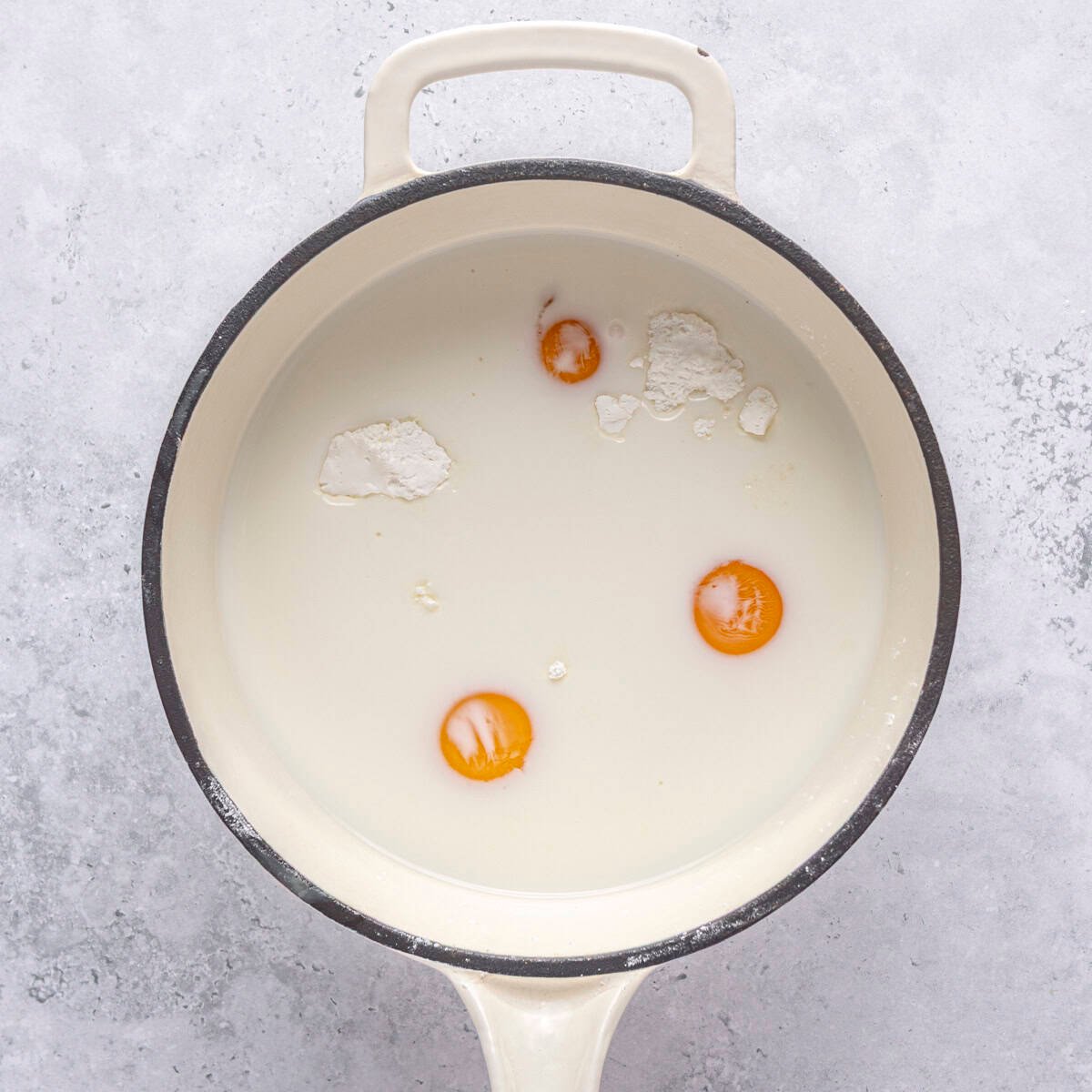 Sugar, cornstarch, milk, egg yolks and salt in a saucepan before mixing.