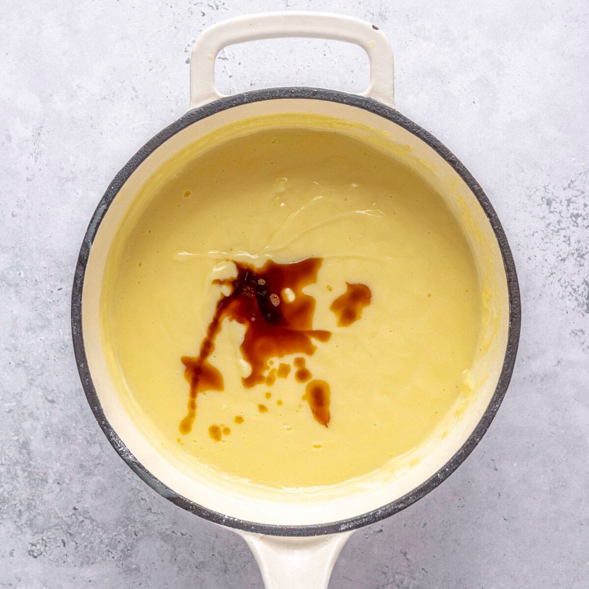 Vanilla extract added on top of thickened pudding.