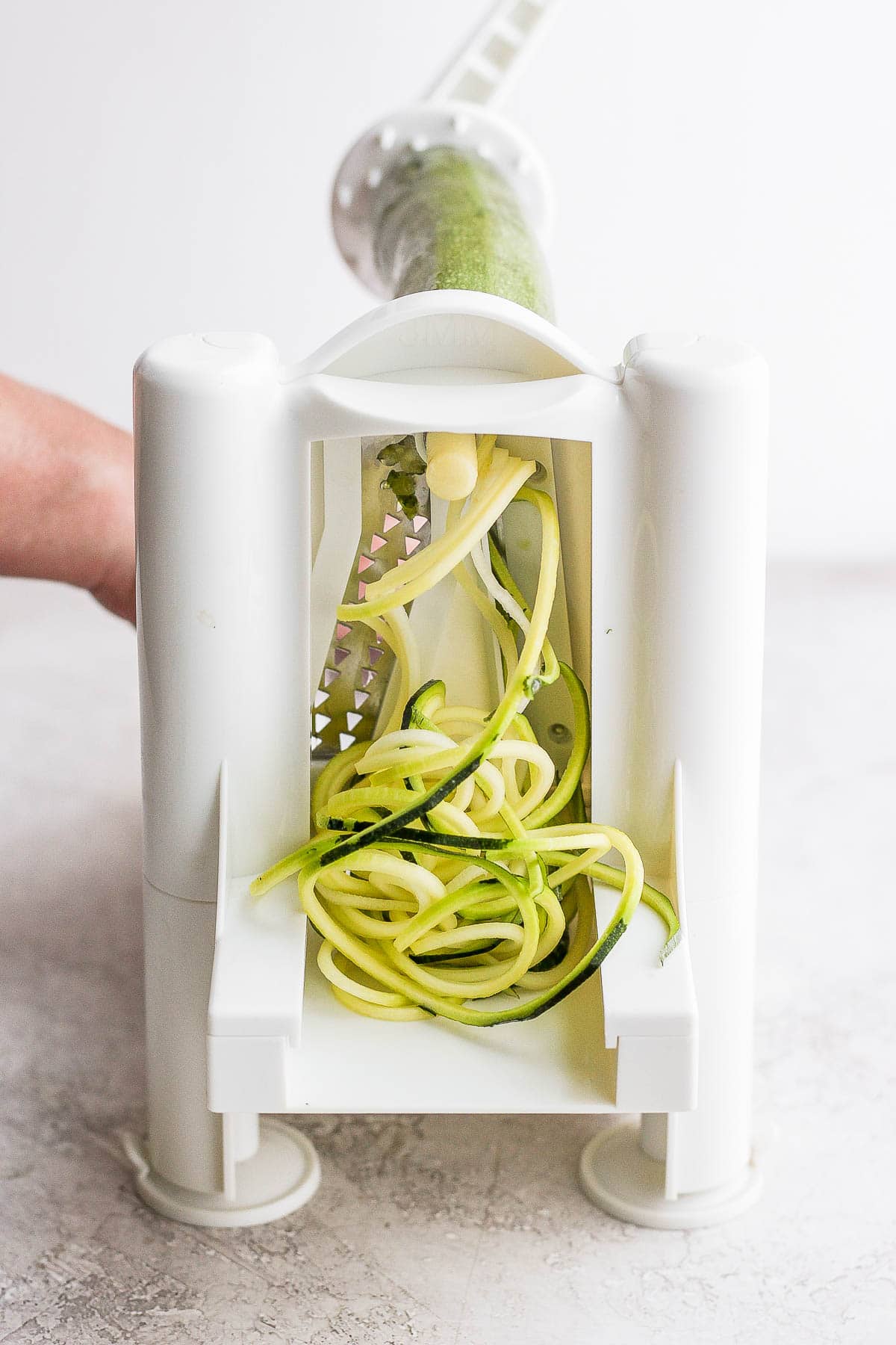 A spiralizer cutting a zucchini into noodles.